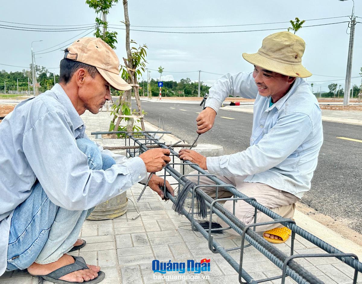 Des ouvriers construisent des maisons pour les personnes réinstallées dans la zone de réinstallation d'An Hoi Bac 1, commune de Nghia Ky.           Photo : Th.Nhi