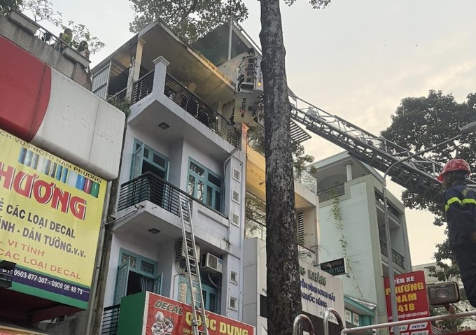 Die Polizei setzte Leitern ein, um Menschen zu retten, die im vierten Stock des brennenden Hauses standen. Foto: Minh Nghiem