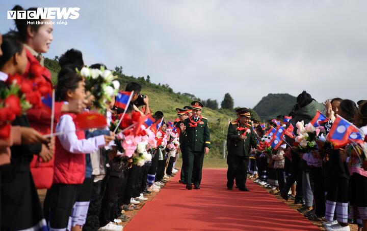 파항 초등학교와 중학교 학생들이 국기와 꽃을 흔들며 두 장관을 환영했습니다. (사진: 트린손)