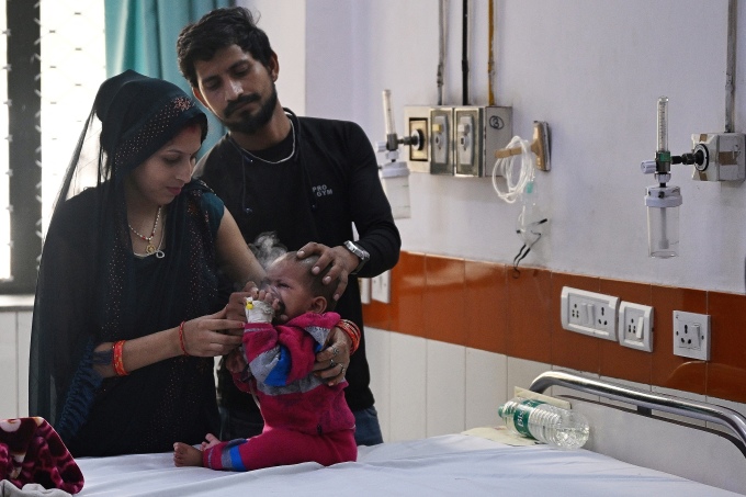 Ein Paar hilft seinem Kind in einem Krankenhaus in Neu-Delhi bei der Benutzung eines Beatmungsgeräts aufgrund der Luftverschmutzung, 7. November. Foto: AFP