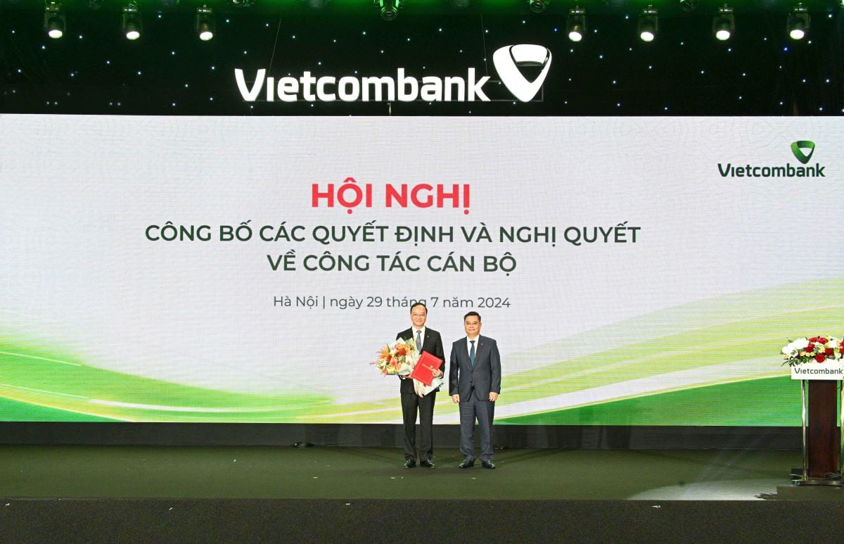 Đồng chí Nguyễn Thanh Tùng - Bí thư Đảng ủy, Chủ tịch HĐQT Vietcombank (bên phải) trao Quyết định và tặng hoa chúc mừng Đồng chí Lê Quang Vinh. Ảnh: Vietcombank.