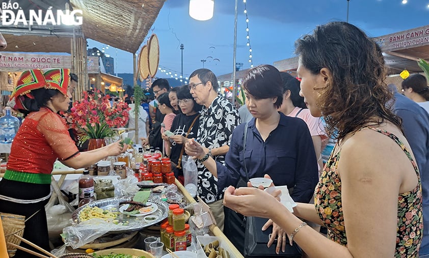 Dans le cadre de l'événement, de nombreuses activités ont eu lieu. Sur la photo : les touristes dégustent la cuisine de l'espace culinaire vietnamien - international. Photo: THU HA