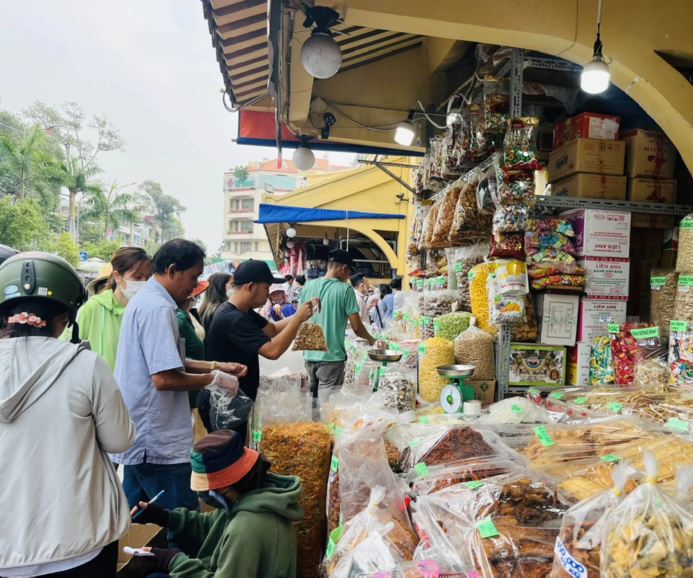 Am Nachmittag des 21. Januar kaufen die Leute auf dem Binh Tay-Markt im Bezirk 6 von Ho-Chi-Minh-Stadt Süßigkeiten aller Art. Foto: THI HONG