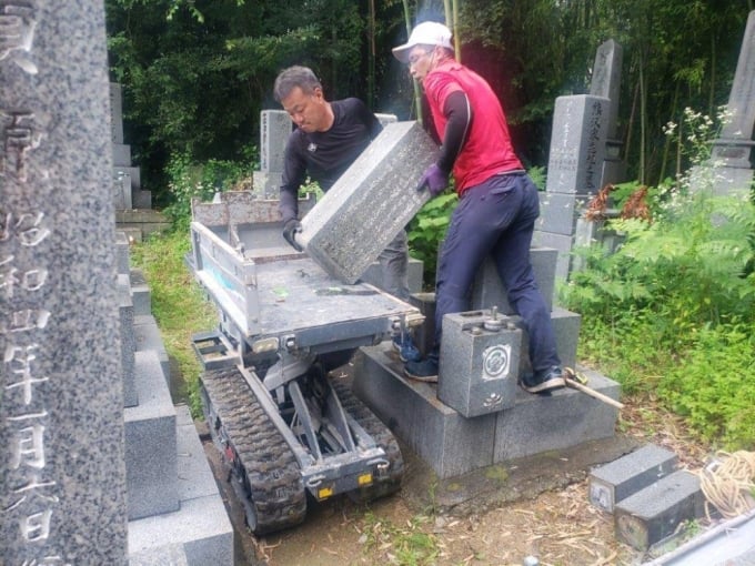 兵庫県姫路市の墓地で、松本さんの先祖の墓を移す作業員たち。写真：ジャパンタイムズ