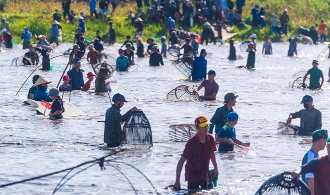 Thousands of people compete to catch fish in the large lagoon on the edge of Hong Linh mountain.