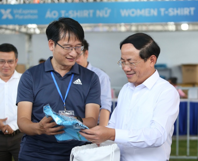 ประธานประจำจังหวัด Pham Anh Tuan รับกระเป๋าชุดแข่งขัน 5 กม. และตรวจสอบสินค้าแต่ละรายการ