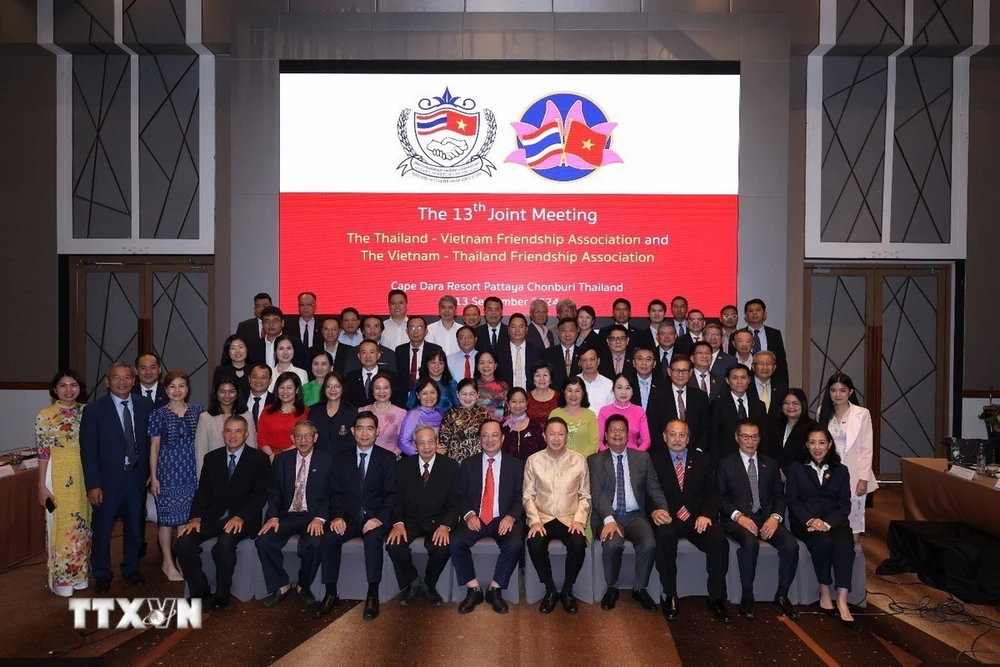 Delegates take souvenir photos at the meeting. (Photo: VNA)