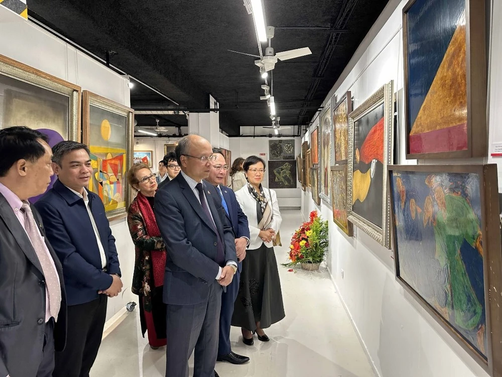 L'ambassadeur du Vietnam en France, Dinh Toan Thang, et les délégués assistent à une présentation de l'exposition de peintures et de produits laqués vietnamiens en France. (Photo : Ngoc Hiep/VNA)
