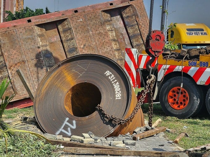 Un rollo de acero de 20 toneladas cayó sobre la acera al lado de un camión con remolque volcado. Foto: Dinh Van