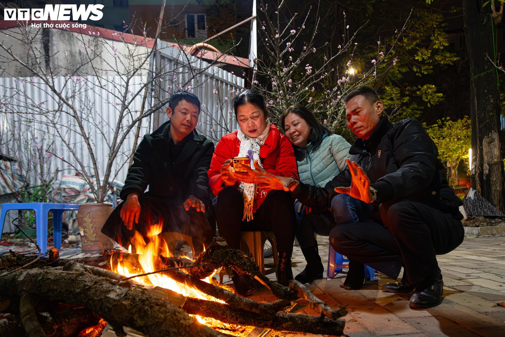 Los pequeños comerciantes luchan contra el frío extremo en Hanoi y se quedan despiertos toda la noche para cuidar los árboles de durazno y kumquat - 10