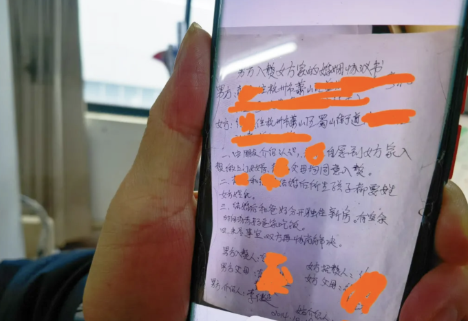 Ein handschriftlicher Ehevertrag für einen Mann, der bei der Familie seiner zukünftigen Frau lebt, unterzeichnet in einer Partnervermittlung. Foto: Sixth Tone
