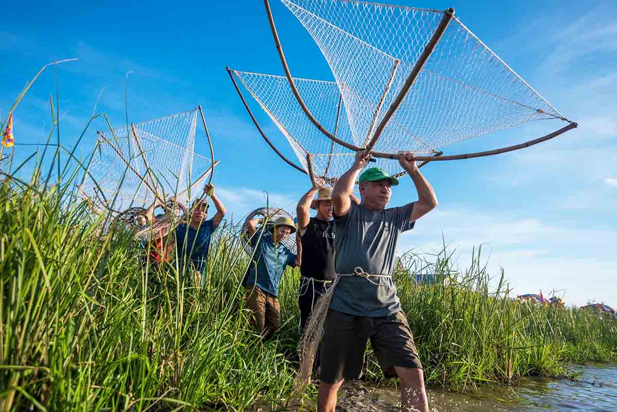 People carry fishing gear to prepare to participate in the festival. Photo: Thien Chan