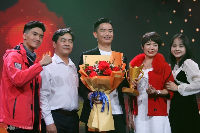 Le tireur Pham Quang Huy (au milieu) avec sa famille après avoir remporté le titre d'athlète masculin de l'année. Photo : Hieu Luong