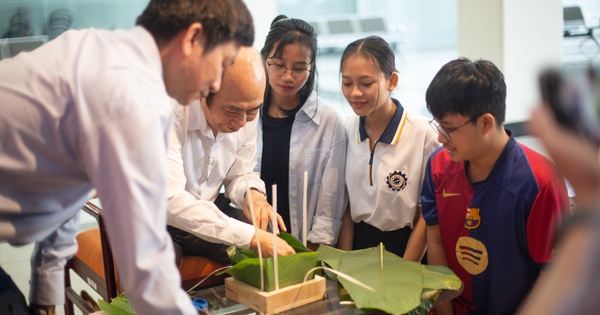 Vietnamesischer Schulleiter zeigt Schülern aus Myanmar das Einwickeln von Banh Chung