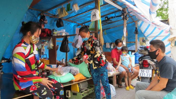 Bauarbeiter im Bezirk 12 erhalten während des Covid-19-Lockdowns in Ho-Chi-Minh-Stadt im August 2021 Lebensmitteltüten. Foto von : Le Tuyet