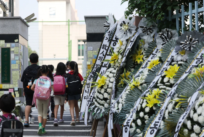 Se colocan coronas de flores frente a una escuela primaria en Seúl después de que un maestro se suicidara, julio de 2023./ Foto: Yonhap