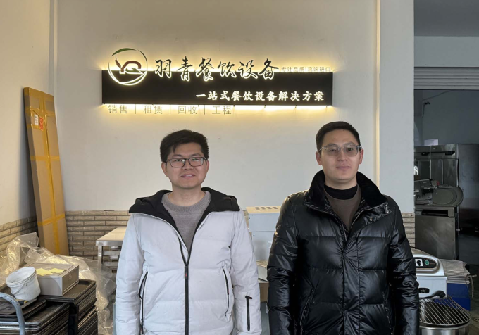 Feng Xing (trái) và đối tác kinh doanh của anh ấy trước bảng hiệu mới của họ. Ảnh: He Qitong
