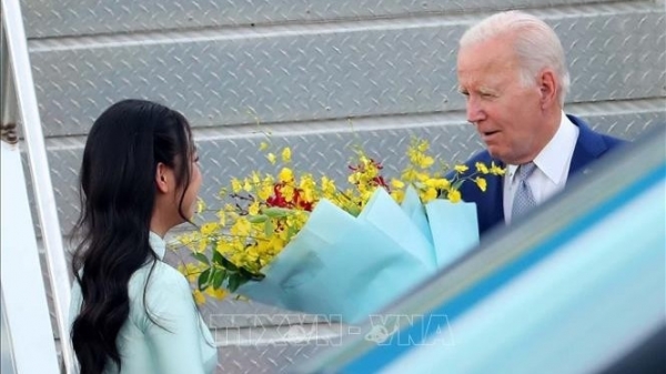 Porträt einer Studentin, die US-Präsident Joe Biden Blumen überreicht