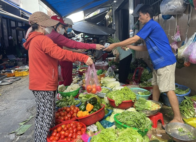 हो ची मिन्ह सिटी के एक पारंपरिक बाजार में ग्राहक प्याज और सब्जियां खरीद रहे हैं। फोटो: हांग चाउ।