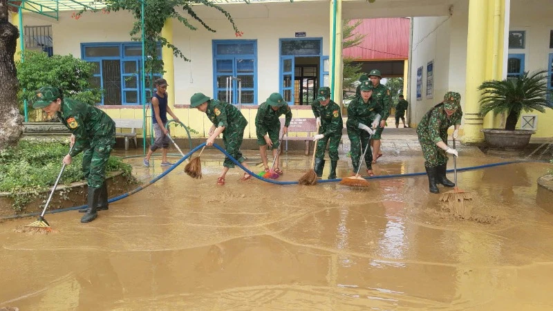 [ภาพ] กองกำลังป้องกันชายแดนจังหวัดกวางบิ่ญช่วยโรงเรียนในพื้นที่น้ำท่วมของจังหวัดเลทุยทำความสะอาดห้องเรียน