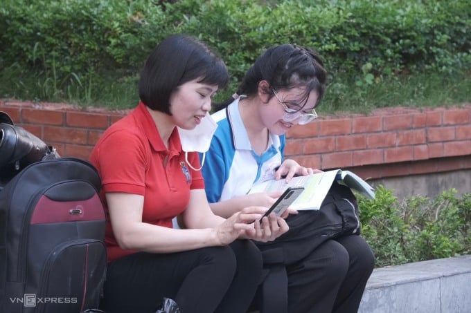 Tue Minh and her mother wait for the exam time on the morning of June 1. Photo: Duong Tam