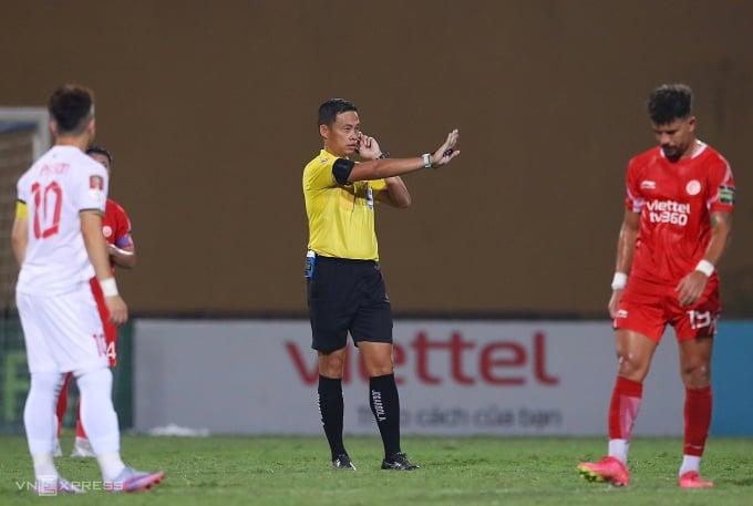 El árbitro Ngo Duy Lan (con camiseta amarilla) escucha los consejos del equipo VAR. Foto: Trung Nhu