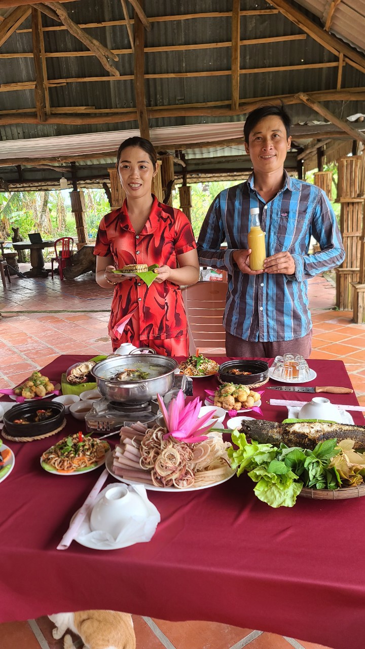 Mr. Khanh and his wife, owners of Muoi Ngọt tourist spot, with a meal made from U Minh Ha forest products (Hoang Nam).