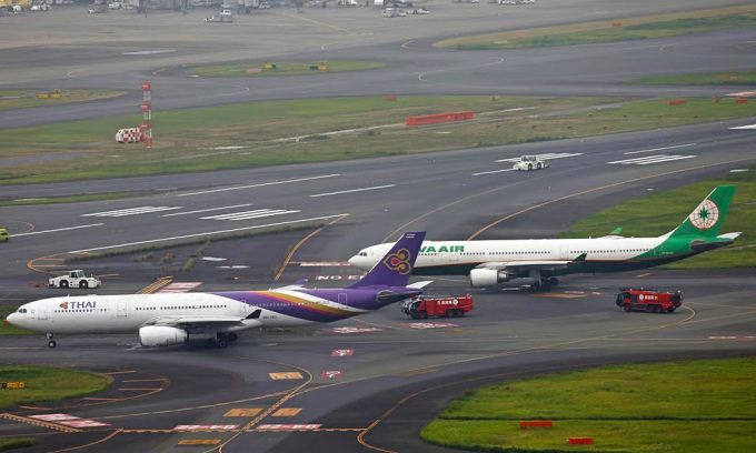 6月10日、東京・羽田空港に停泊中のタイ航空とエバー航空の飛行機。写真：共同通信