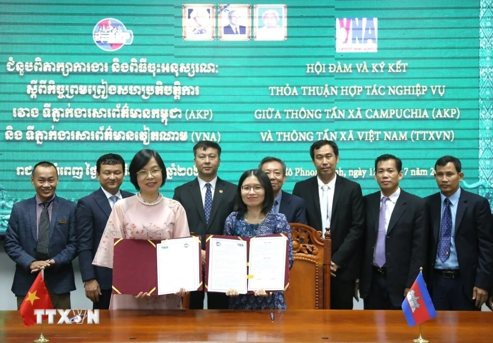 VNA General Director Vu Viet Trang (left) and AKP General Director Sokmom Nimul discuss the newly signed professional cooperation agreement. (Photo: Hoang Minh/VNA)