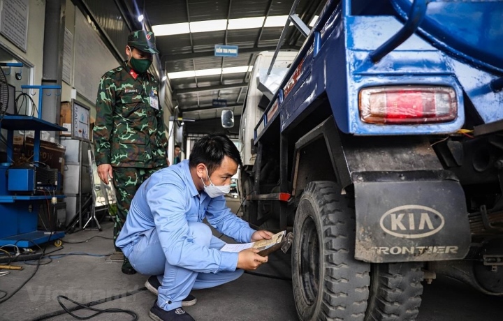 Le personnel d’inspection des véhicules effectue les procédures d’inspection des véhicules à moteur. (Photo : Hoai Nam/Vietnam+)