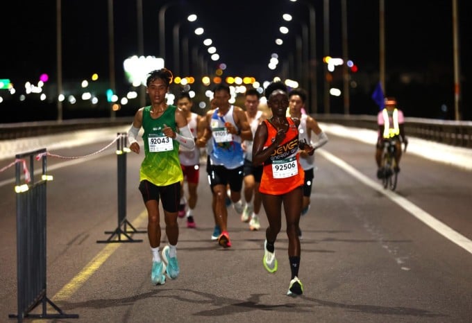 Shelith races with the top runners in the men's 42km race. Photo: Quynh Tran