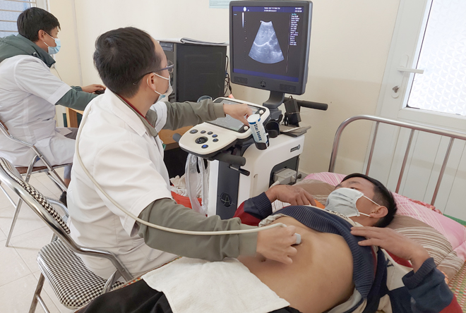 Medical staff perform ultrasound on patients at Tram Tau District Medical Center.