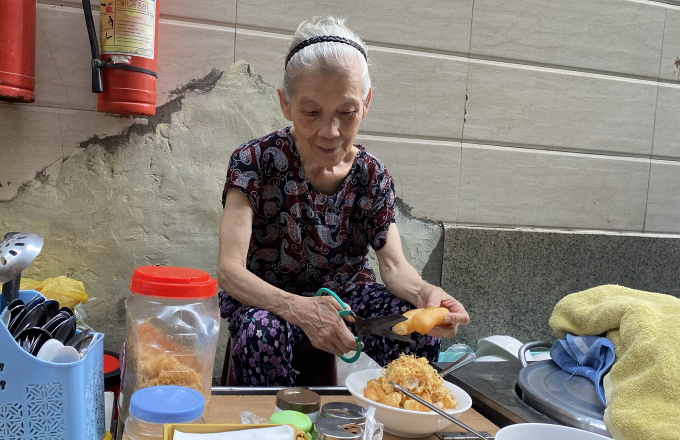 La Sra. Lien es la propietaria de la tienda original de gachas de costillas en el callejón Hang Chi. Foto: Thuy Linh