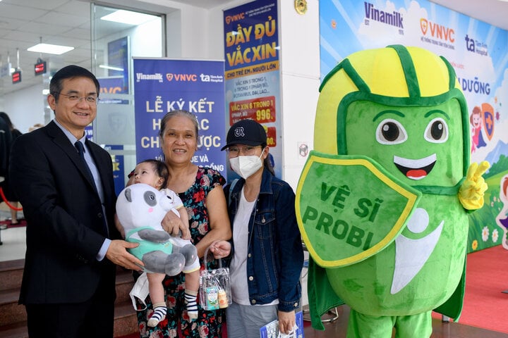 M. Nguyen Quang Tri, PDG de Vinamilk, a offert des cadeaux aux familles et aux enfants venus se faire vacciner au Centre VNVC le jour de la signature de l'accord de coopération. (Photo : Vi Nam)