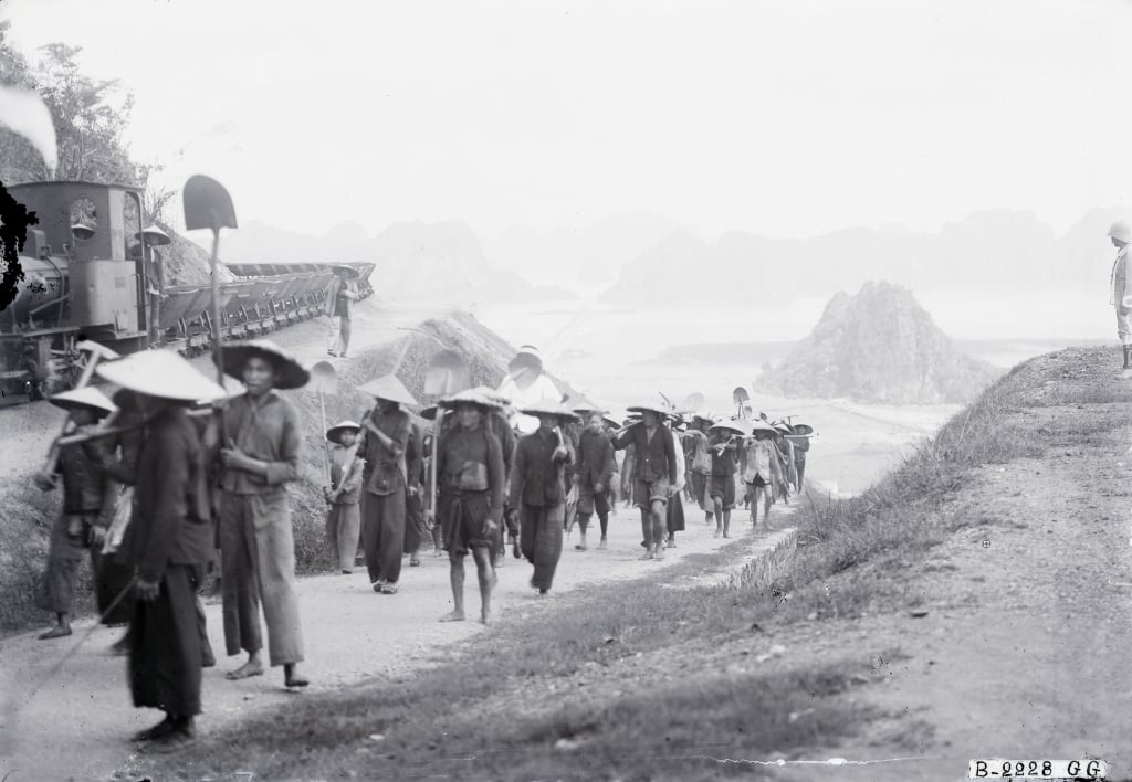 Cảnh công nhân vào ca làm việc tại mỏ than Hòn Gai năm 1929. Bìa phải ảnh có cai Tây đứng theo dõi. Nguồn: Flick/Mạnh Hải