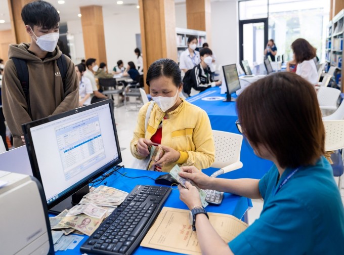 학부모들이 8월 25일 호치민시 산업무역대학에서 자녀들의 수업료를 내고 있다. 사진: HUIT