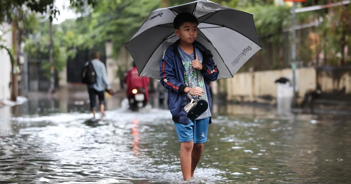 Menschen und Touristen waten nach heftigen Regenfällen in Ho-Chi-Minh-Stadt durch Wasser