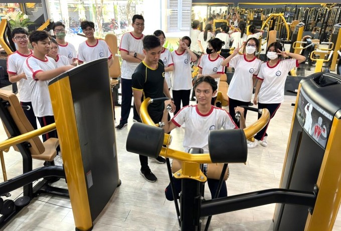 Students at Marie Curie High School, Ho Chi Minh City, exercise with machines in the gym during physical education class. Photo: Le Nguyen