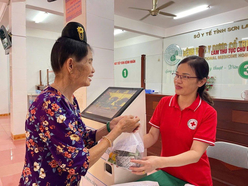 Los funcionarios de la Asociación Provincial de la Cruz Roja de Son La amablemente pidieron y animaron a los ancianos después de recibir medicamentos de los médicos y enfermeras. Foto: Asociación Provincial de la Cruz Roja de Son La