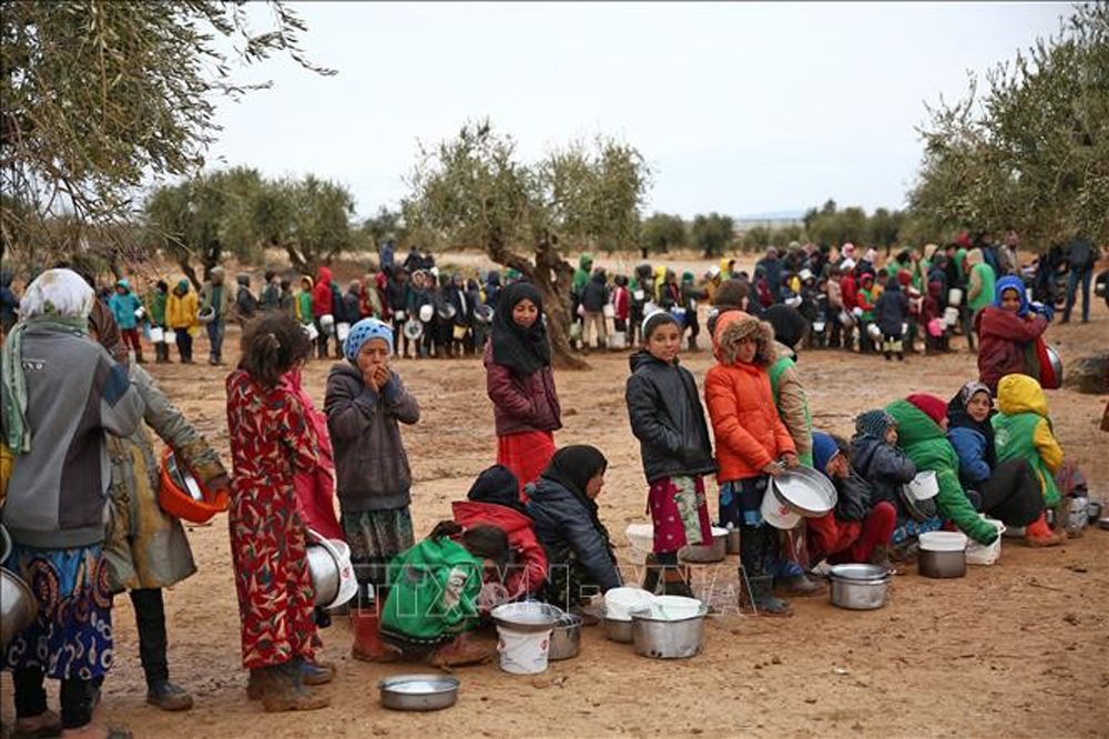 Barn köar för att få mathjälp i ett flyktingläger i Aleppo, Syrien.