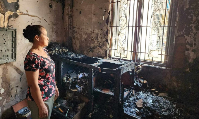 Ms. Trang stands in the room where the fire spread from the level 4 house that killed her and her child on the morning of June 28. Photo: Dinh Van