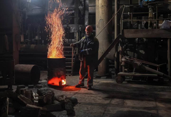 Workers warm themselves while repairing a damaged thermal power plant. (Photo: Reuters)