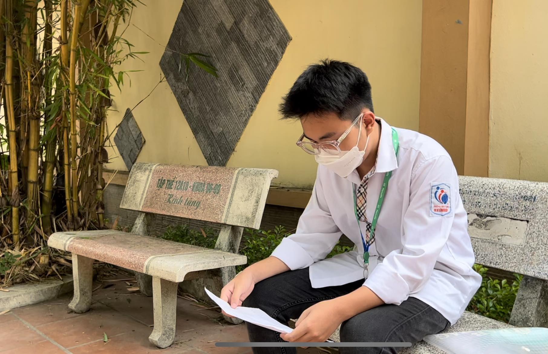 Thí sinh đến điểm thi từ sớm và tranh thủ ngồi ôn lại bài. Ảnh: Hoài Luân