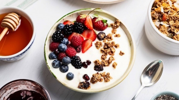 Desayuno equilibrado con yogur griego, frutos secos y fruta fresca.