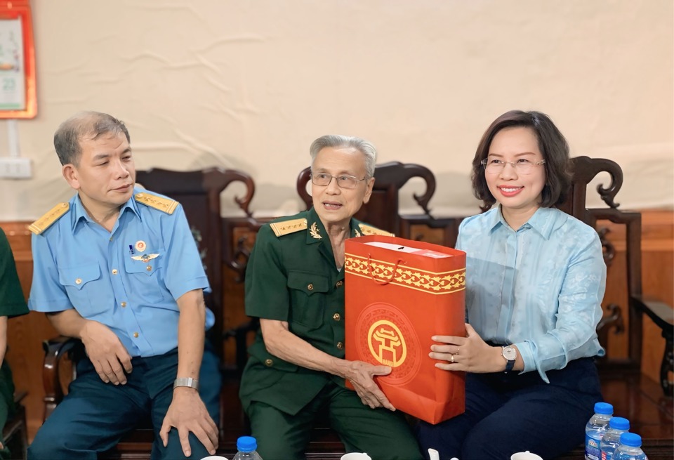 El secretario del Partido del distrito de Thanh Xuan, Bui Huyen Mai, visitó y entregó obsequios al veterano Le Van Tinh.