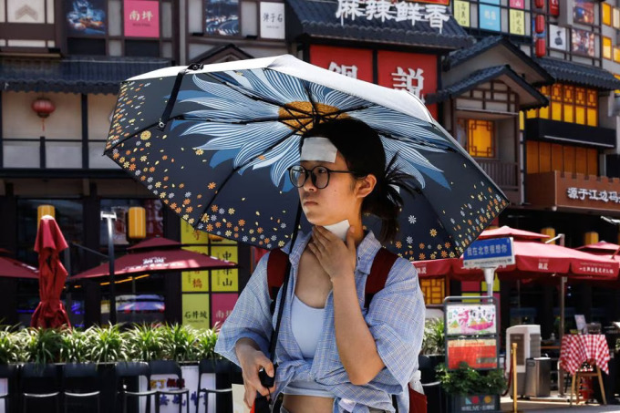 北京で6月23日、暑さ対策に冷感パッチを使う女性。写真：ロイター
