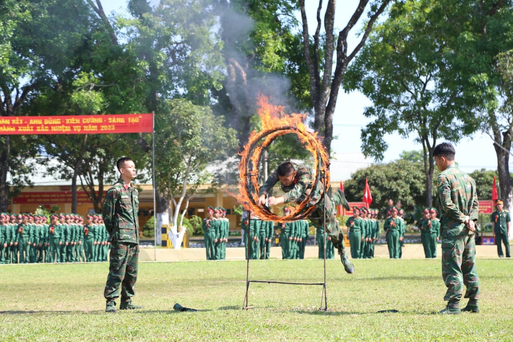 Les nouveaux soldats du Régiment 43 (Division 395) effectuent un saut à travers un anneau de feu lors de la cérémonie de prestation de serment.