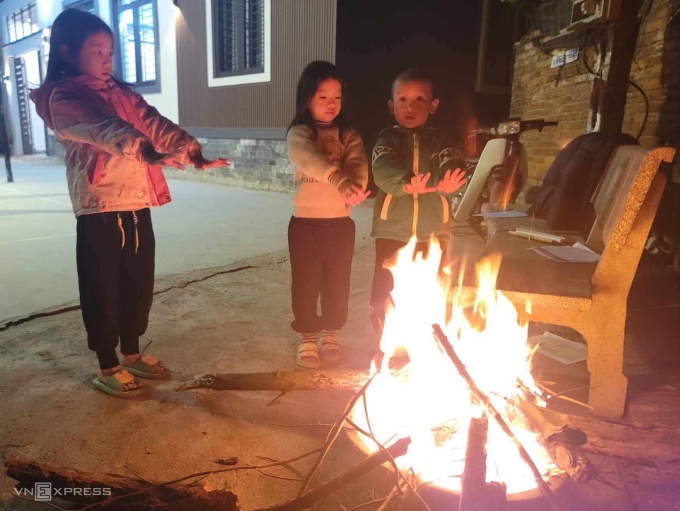 Kinder wärmen sich während der Kälteperiode im Dezember 2023. Foto: Gia Chinh