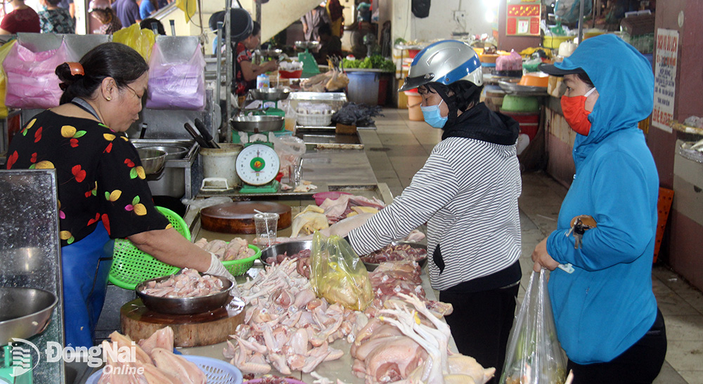 Les gens achètent du poulet au marché de Bien Hoa. Photo : Marine