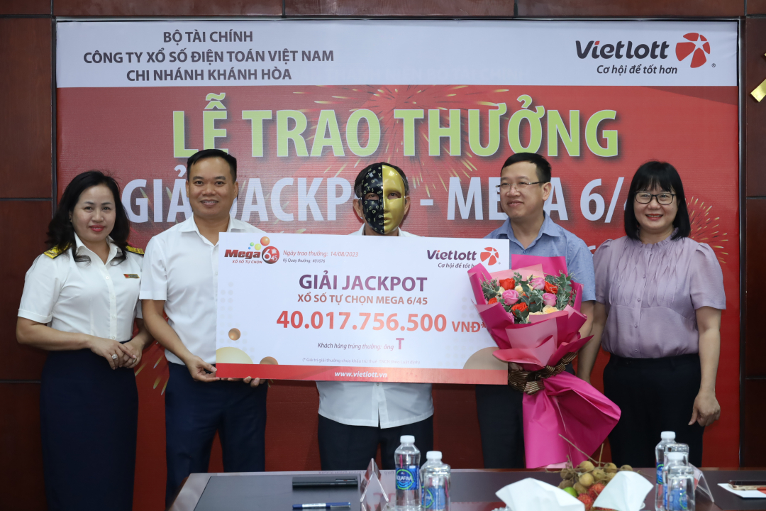 Đại diện Vietlott Chi nhánh Khánh Hòa và các cơ quan chức năng trao giải cho khách hàng may mắn.